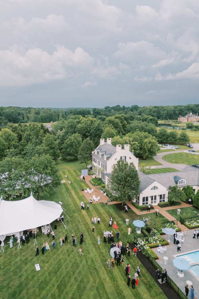 Aerial and scenic views of a luxury tented estate wedding in Ohio, featuring two sailcloth tents, poolside cocktail hour spaces, and detailed outdoor setups planned by an expert Ohio wedding planner.