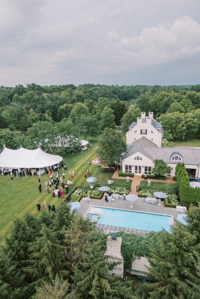 Aerial and scenic views of a luxury tented estate wedding in Ohio, featuring two sailcloth tents, poolside cocktail hour spaces, and detailed outdoor setups planned by an expert Ohio wedding planner.