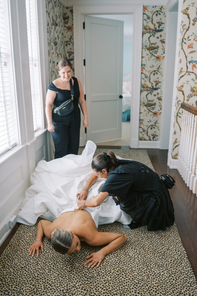 columbus wedding coordinator zipping bride in dress