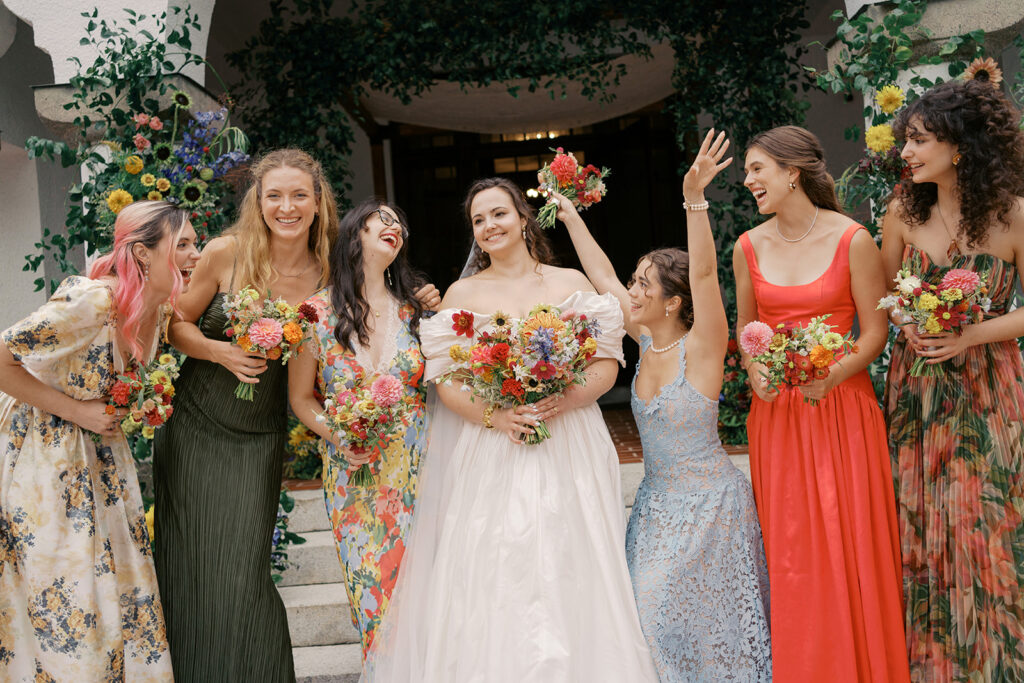 Bridal party smiling together in colorful, floral-inspired dresses at Hill House Durham.