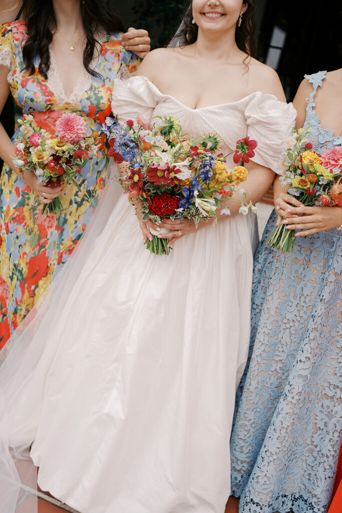 Bridal party smiling together in colorful, floral-inspired dresses at Hill House Durham.