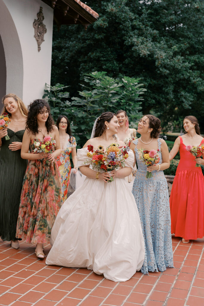 Bridal party smiling together in colorful, floral-inspired dresses at Hill House Durham.
