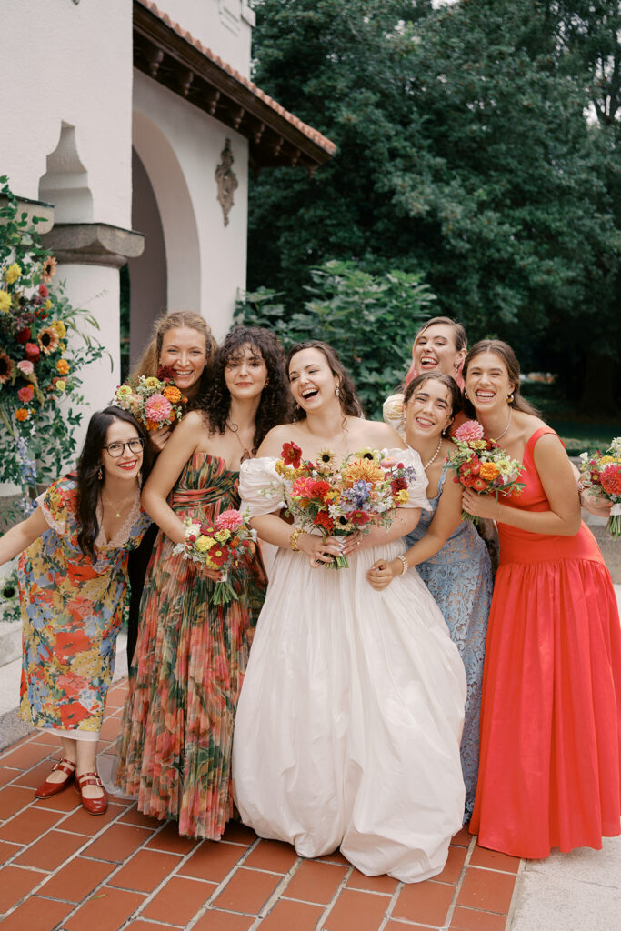 Bridal party smiling together in colorful, floral-inspired dresses at Hill House Durham.
